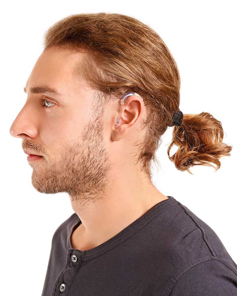Young man with hearing aid on white background